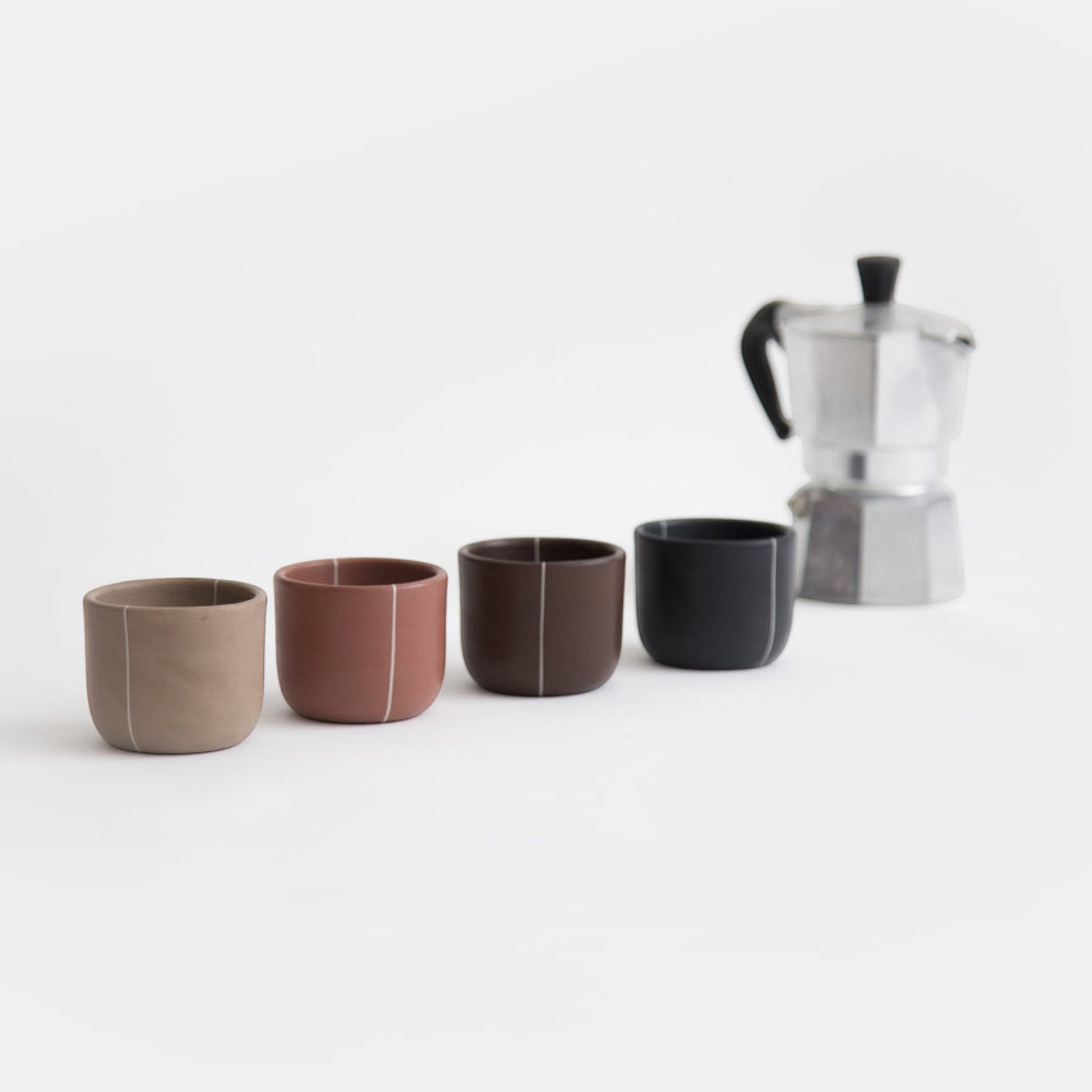 Set of espresso cups in four colors on white background