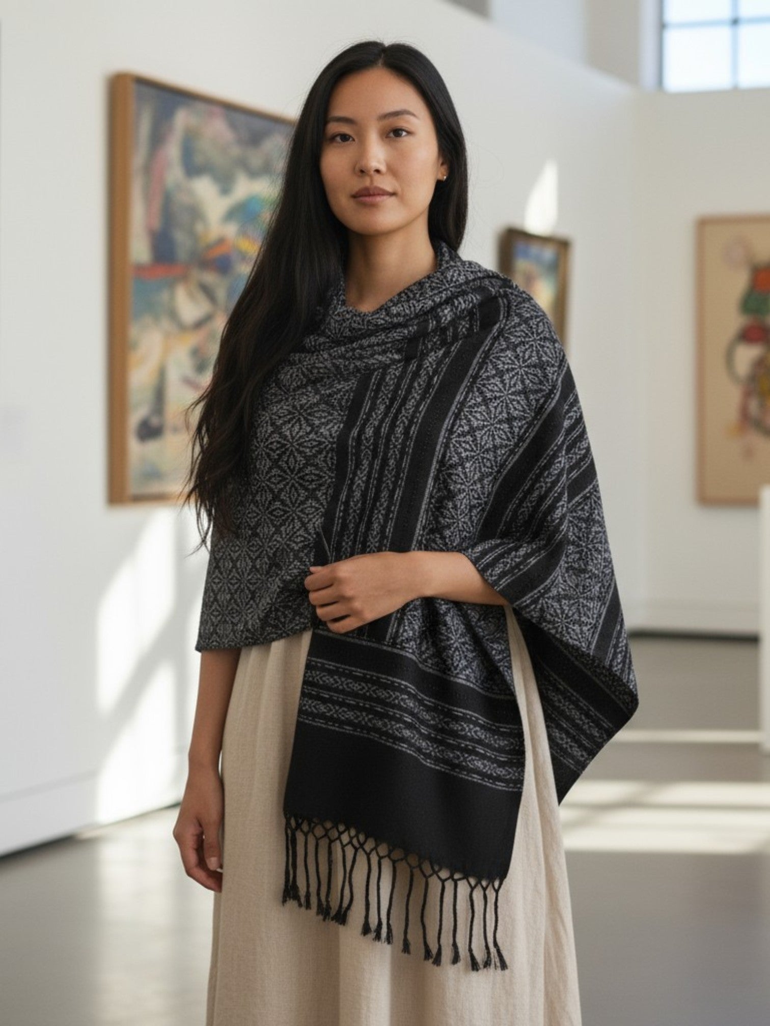 Mexican handwoven rebozo shawl in charcoal and black worn as a shawl, highlighting floral pattern and soft drape.
