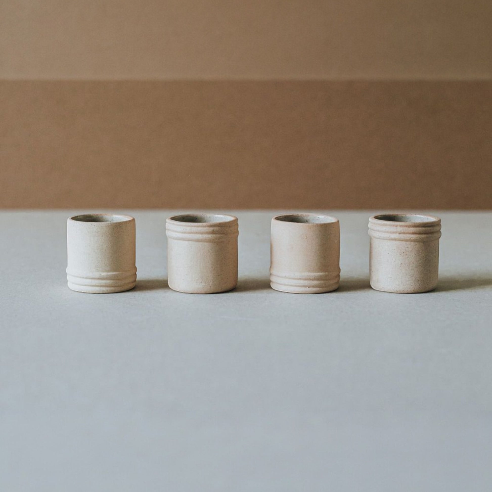 Artisan mezcal shot cup held in hand to show scale and matte finish