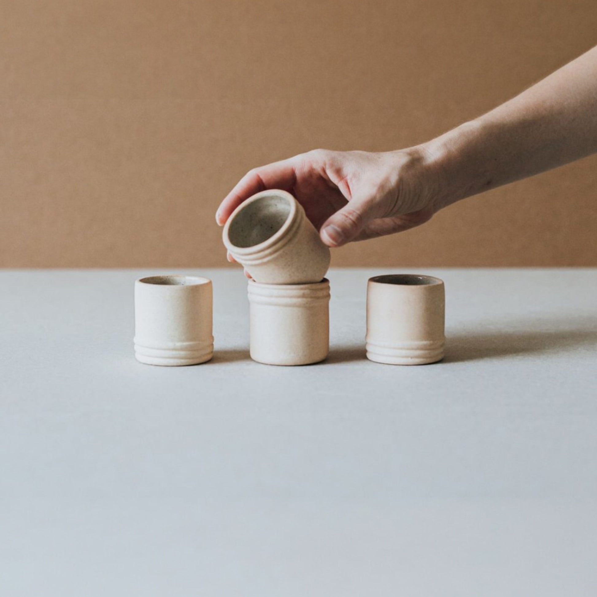 Hand holding ceramic shot glass to show craftsmanship and proportions