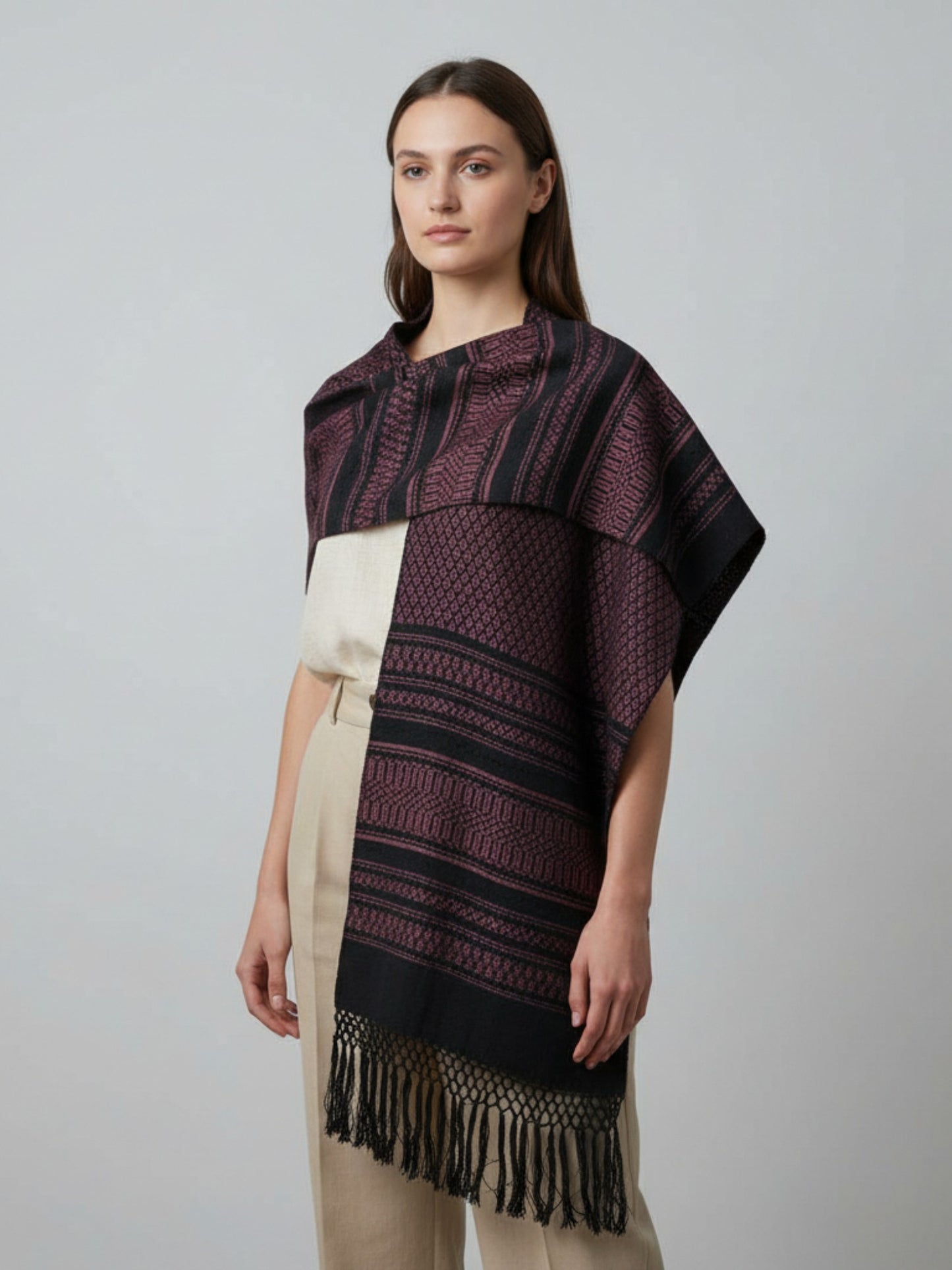 Handwoven cotton rebozo shawl in mauve tones, worn over a neutral dress, featuring diamond woven pattern and hand-tied fringe