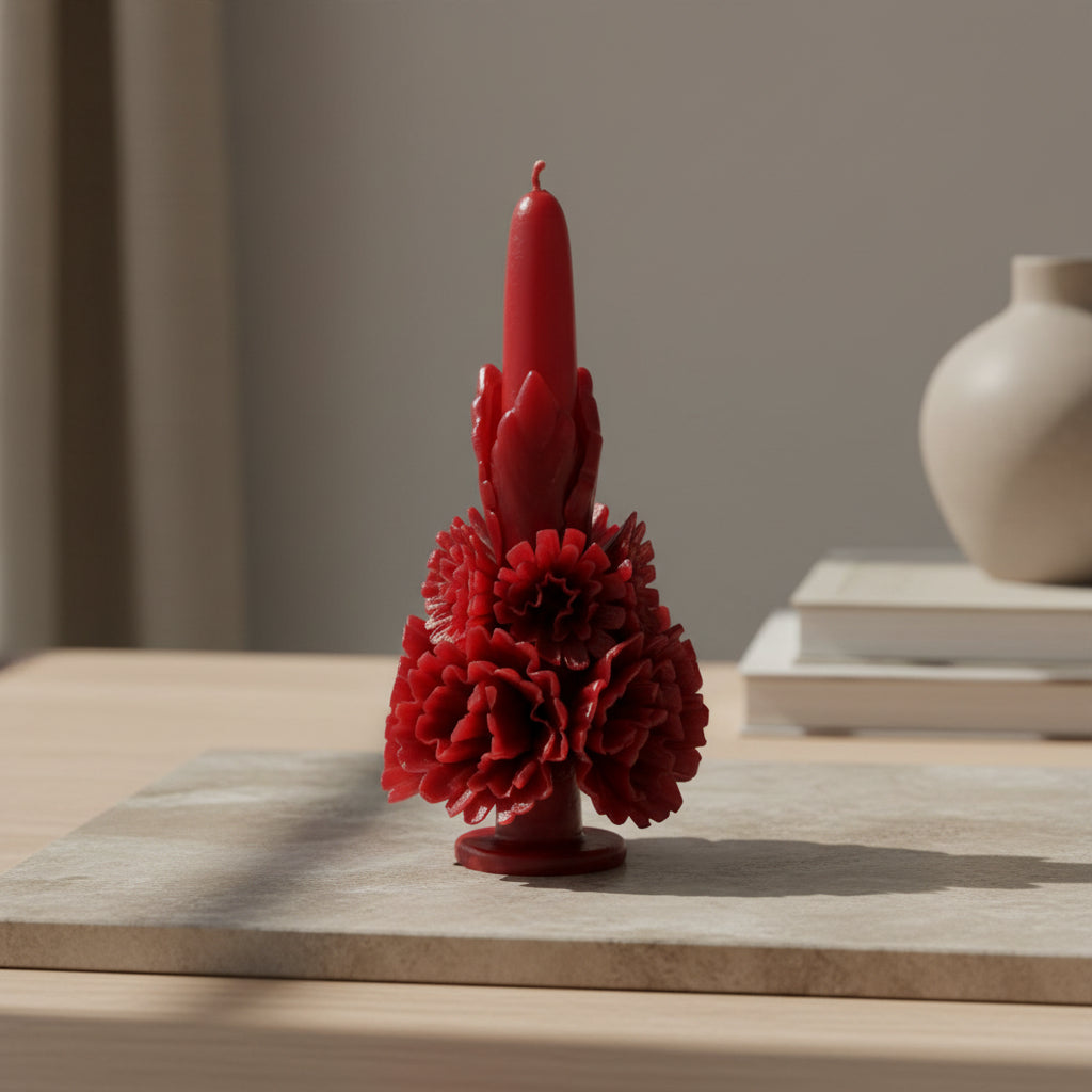Red carved beeswax floral candle on a wooden surface with neutral decor