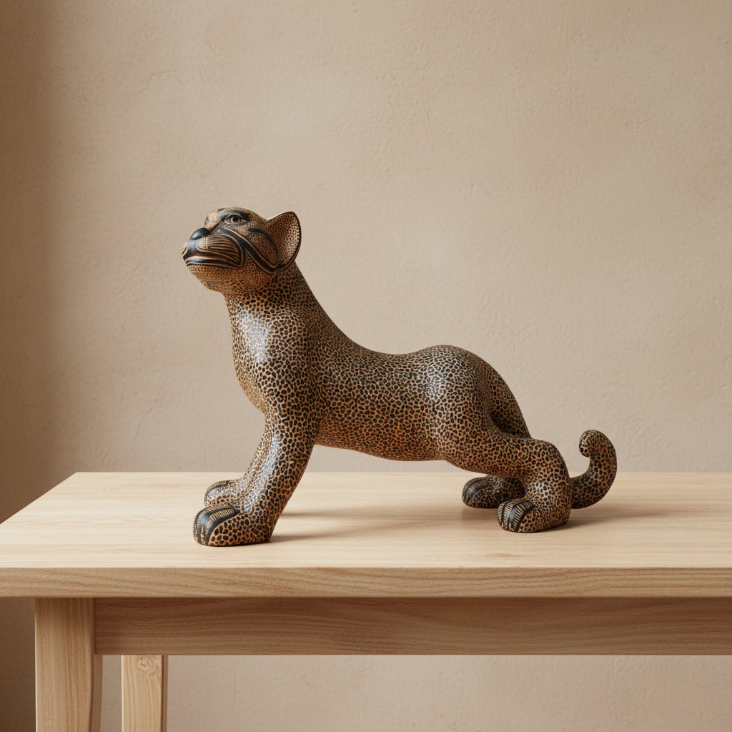 Mayan clay jaguar figurine styled on a wooden shelf with books, ceramic vase, and candle in a minimalist home setting