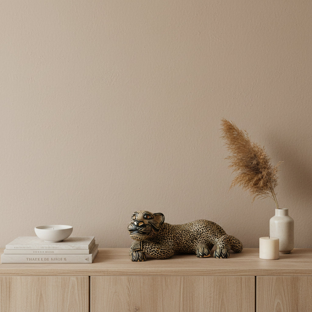 Decorative clay jaguar sculpture on a wooden console with pampas grass and neutral-toned décor