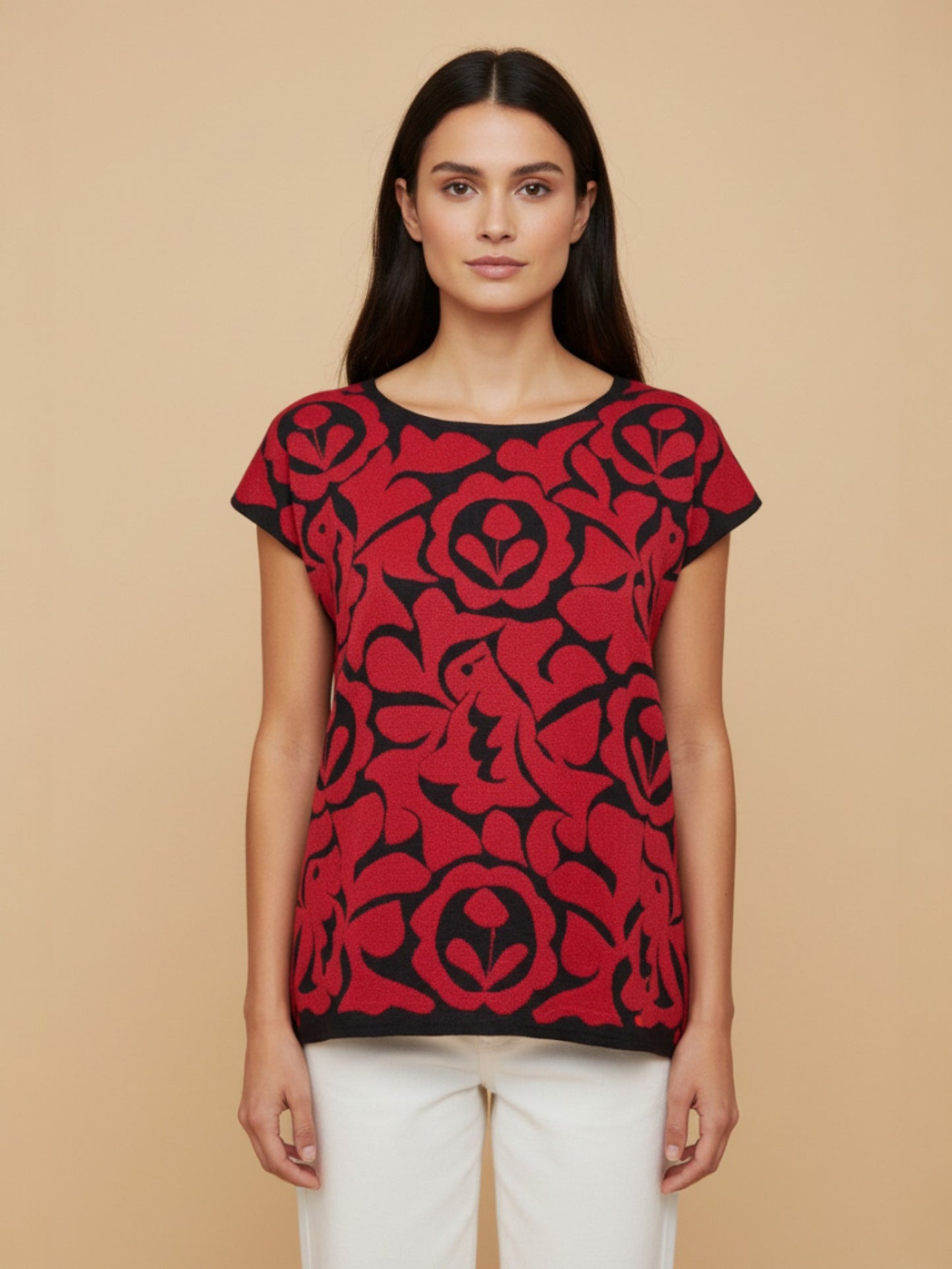 Oaxacan Istmo floral blouse with red and black Tehuana-inspired pattern, cotton-blend knit, front view on model against a neutral background
