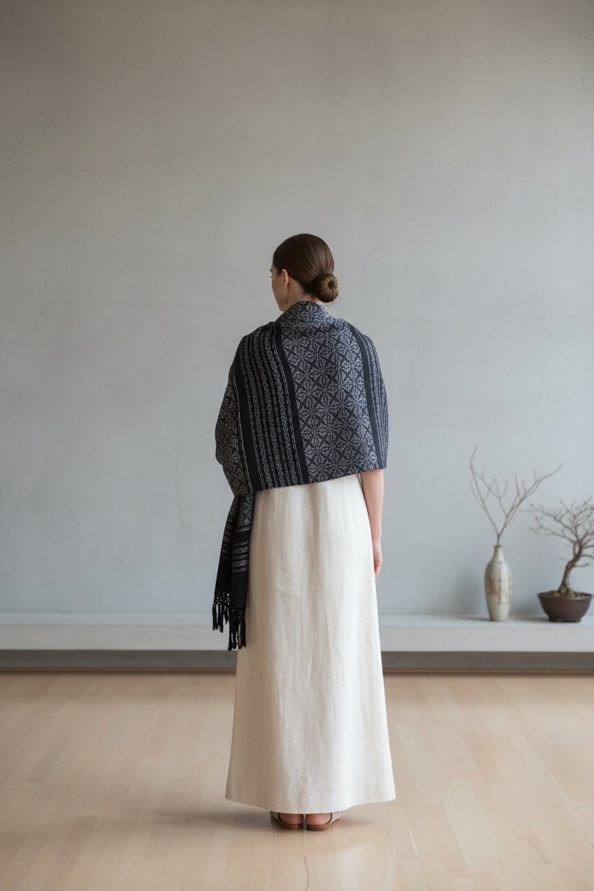 Back view of a handwoven Mexican cotton rebozo shawl in charcoal and black with traditional floral pattern.