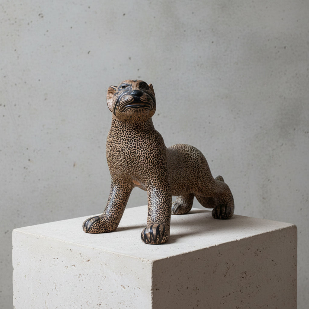 Handmade Mayan clay jaguar sculpture on a wooden table with a warm neutral wall background