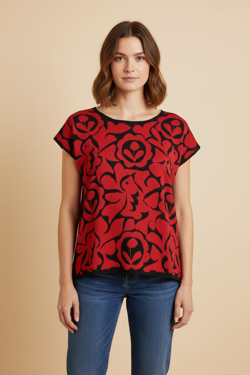 Oaxacan Istmo floral blouse worn with blue jeans, relaxed fit cotton-blend knit top with red and black floral motifs